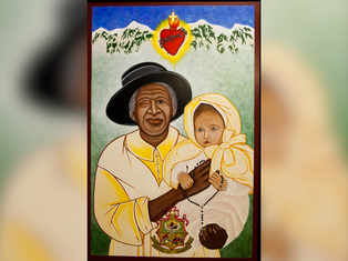 Woman in black hat and beige robe holds a baby in white attire with a rosary. Heart symbol above. Green background with mountains.