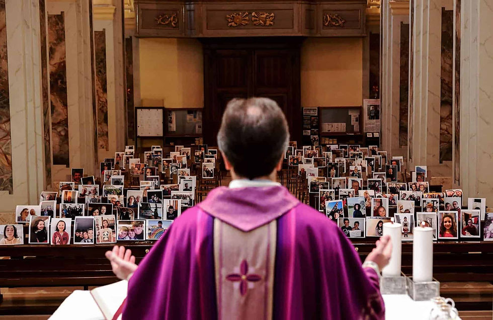 TOPSHOT - Don Giuseppe Corbari, parson of the Church of Robbiano, holds Sunday mass as he looks towards selfie photographs sent in by his congregation members and glued to empty pews in Giussano on March 22, 2020. - Italian Prime Minister Giuseppe Conte on March 21 ordered all non-essential companies and factories to close nationwide to stem a coronavirus pandemic that has killed 4,825 people in the country in a month. "The decision taken by the government is to close down all productive activity throughout the territory that is not strictly necessary, crucial, indispensable, to guarantee us essential goods and services," Conte said in a late-night TV address (Photo by Piero CRUCIATTI / AFP) (Photo by PIERO CRUCIATTI/AFP via Getty Images)