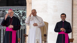 Pope in white robe salutes at a podium, flanked by two black-and-magenta clergy in a solemn ceremony.