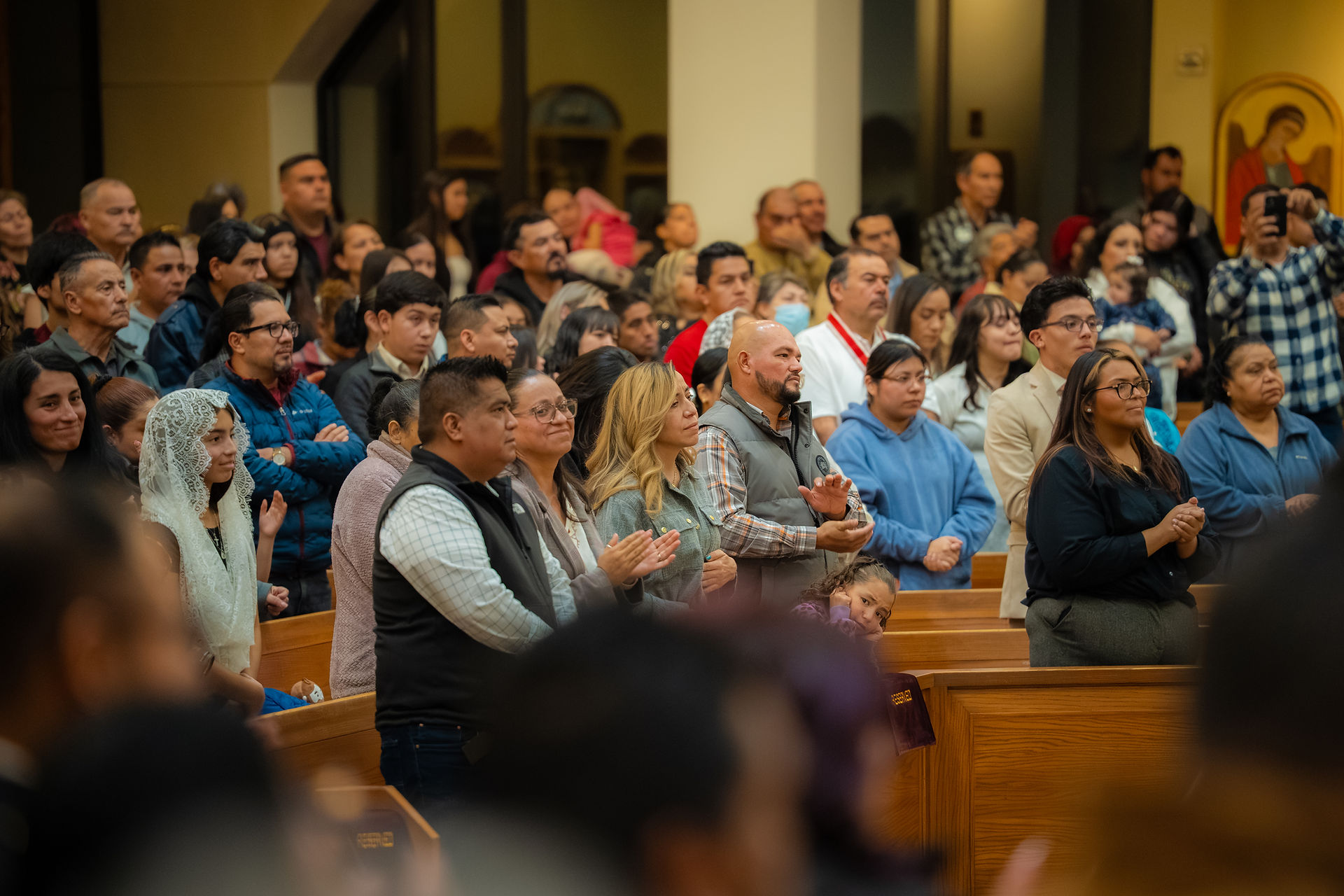 A full church during a religious service. The mood is warm and prayerful.