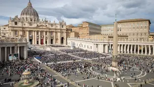 Crowd gathers in St. Peter's Square, Vatican City, under cloudy skies. The basilica and obelisk are prominent. Mood is solemn and lively.
