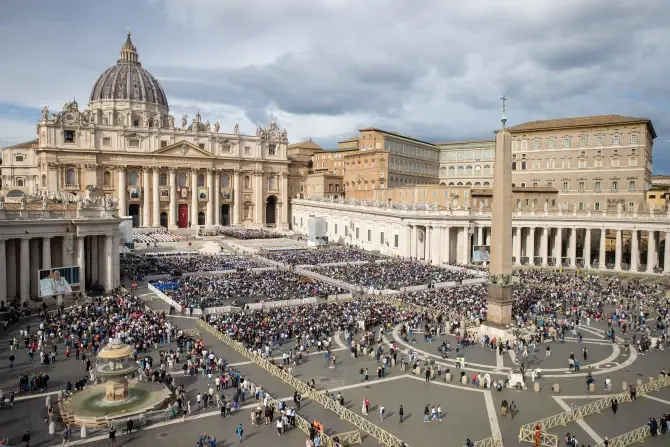 Crowd gathers in St. Peter's Square, Vatican City, under cloudy skies. The basilica and obelisk are prominent. Mood is solemn and lively.
