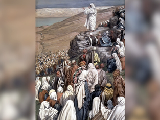 A figure dressed in white speaks to a large crowd on a hillside. People wear robes in earth tones. The mood is attentive and reverent.