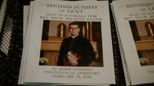 Mass program featuring a priest in black robes, gold church altar in background. Text: Second Sunday of Lent, Feb 28, 2026.