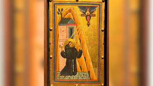 Monk kneels beside building, gazing at six-winged seraph on the cross. Icon has vibrant gold, orange, and black hues. Spiritual aura.