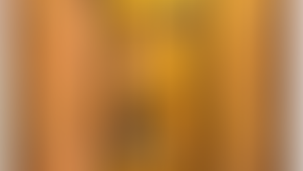 Monk kneels beside building, gazing at six-winged seraph on the cross. Icon has vibrant gold, orange, and black hues. Spiritual aura.