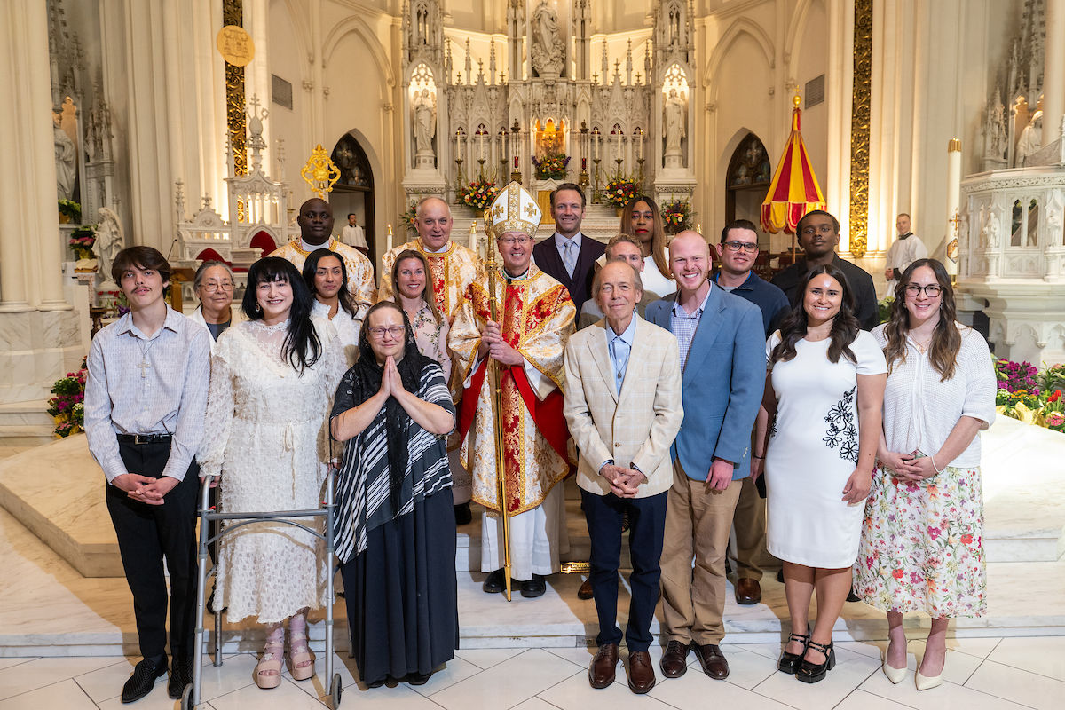 A group of parishioners pose with a bishop inside the cathedral after Mass.