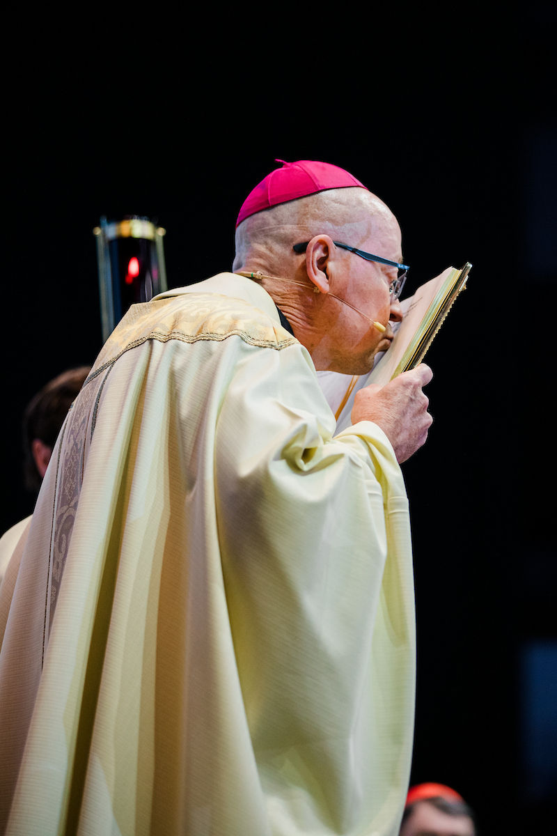 A bishop reverently kisses the Book of the Gospels during the liturgy.