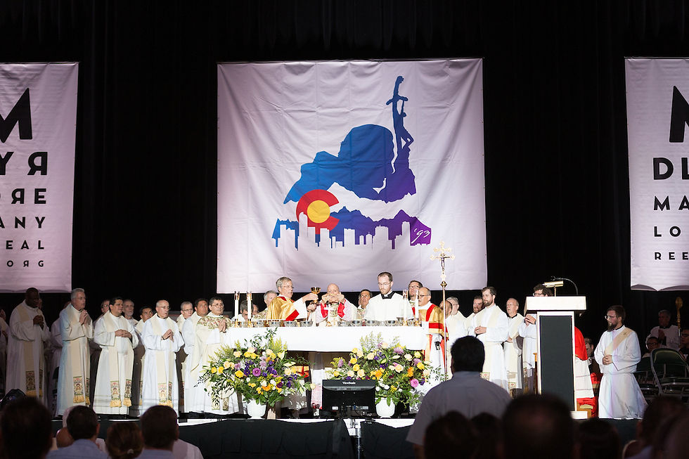 Clergy in white robes conduct a religious service onstage with banners and flowers. A large backdrop features a colorful city silhouette.