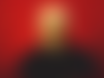 Portrait of an elderly man with glasses wearing dark clothing against a vivid red background, expressing a serious demeanor.