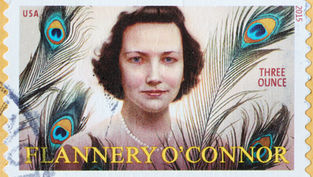 USA stamp featuring a woman with peacock feathers in the background. Text: "FLANNERY O'CONNOR, THREE OUNCE." Vibrant colors.