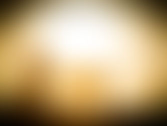 Silhouette of a person kneeling in prayer beside a manger at sunset, with golden light creating a peaceful, reverent mood.