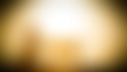 Silhouette of a person kneeling in prayer beside a manger at sunset, with golden light creating a peaceful, reverent mood.