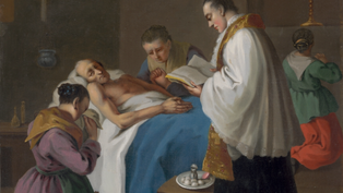 Priest reads to a sick man in bed, two women pray beside them in a dim room. Somber mood with blue and white bedding, candles lit.