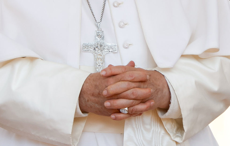 Hands clasped in prayer, wearing white religious garments and cross necklace. A serene, spiritual atmosphere is conveyed.