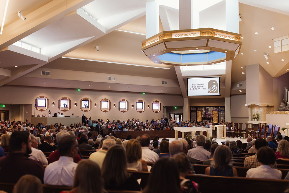 A congregation inside a church, seated and standing, with a screen displaying "Twentieth Sunday in Ordinary Time." Warm lighting and organ pipes seen.