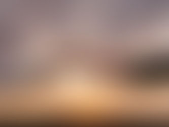 Two hands reaching toward each other at sunset, set against a dramatic sky. One hand is in a dark sleeve, the other in white.