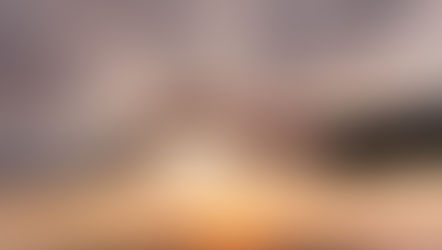 Two hands reaching toward each other at sunset, set against a dramatic sky. One hand is in a dark sleeve, the other in white.