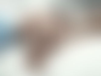 Hands of an elderly person being gently held by a younger person on a white blanket, conveying warmth and care in a soft-focus setting.