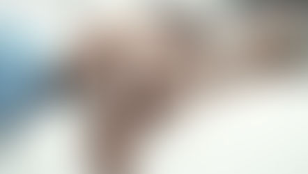 Hands of an elderly person being gently held by a younger person on a white blanket, conveying warmth and care in a soft-focus setting.