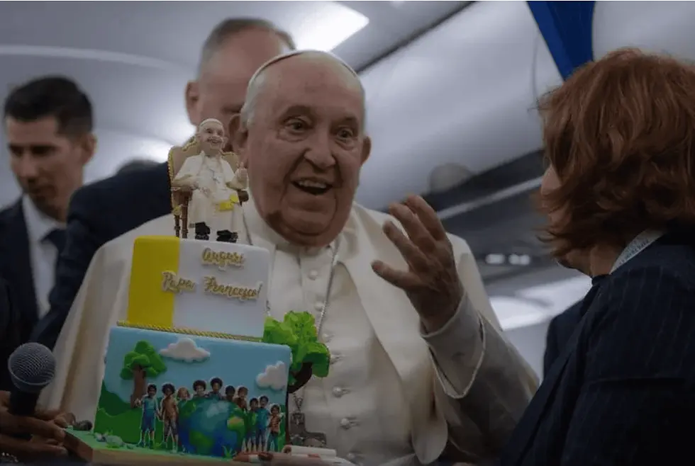 Pope Francis is presented with a birthday cake aboard the papal plane on the return from his trip to Corsica on Sunday, Dec. 15, 2024. He celebrates his 88th birthday today. (Photo: Daniel Ibanez/CNA / EWTN)