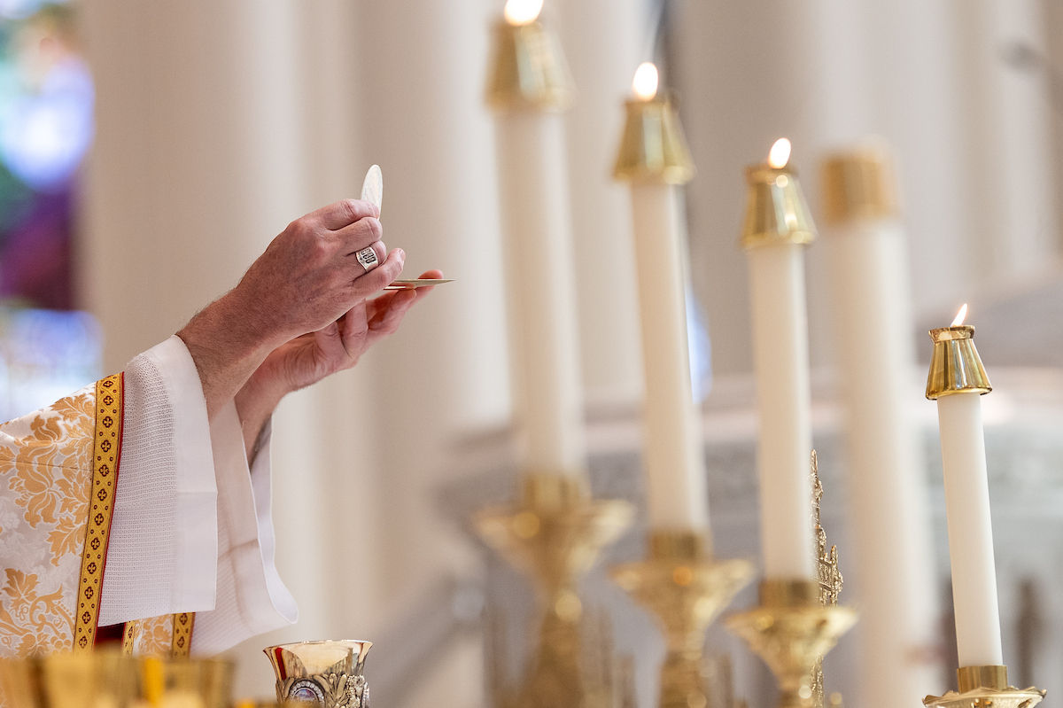 Close-up of a bishop elevating the host during the consecration at Mass.