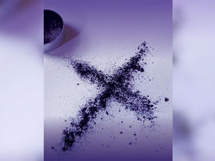 A purple powdery "X" on a white surface, with a metal tin lid nearby. The image has a soft purple gradient, creating a mysterious mood.