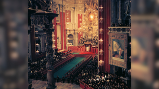 Ornate church interior with a large gathering of people. Red and gold decor dominates. Illuminated altar and religious art visible.
