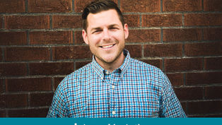 Man in blue checked shirt smiles in front of a brick wall. Text below reads "Appeal in Action" on a teal banner.
