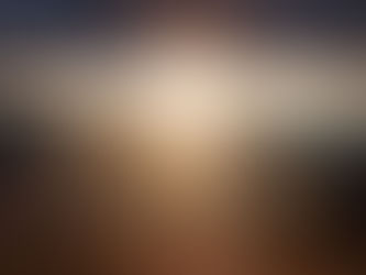 A person stands on a mountain peak at sunset, with sunbeams breaking through clouds. Majestic landscape, warm colors create a serene mood.