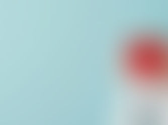 Hands in white sleeves hold a red heart against a pale blue background, conveying warmth and care.