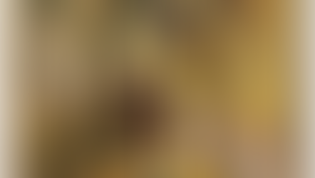 Medieval painting of Saint Francis kneeling with halo as an angel descends, on a gold background with small buildings.