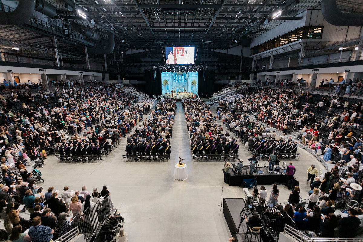 A wide view of the arena shows thousands gathered for the installation Mass.