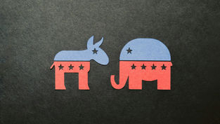 Blue and red paper cutouts of a donkey and elephant with stars on a dark background, symbolizing political parties.