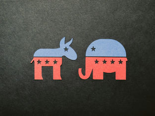 Blue and red paper cutouts of a donkey and elephant with stars on a dark background, symbolizing political parties.