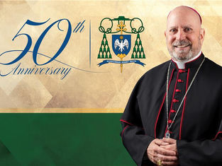 A smiling cleric in black robes. "50th Anniversary" text and a crest appear on a beige and green background.