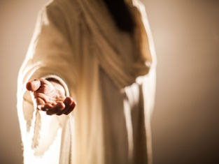 Outstretched hand in a flowing, cream-colored robe, reaching forward in soft lighting. Background is blurred, creating a serene atmosphere.