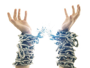 Hands bound in metal chains breaking free against a white background. Chains shatter, symbolizing liberation and strength.