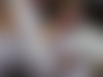 People in white robes stand with hands clasped in prayer. The setting is a solemn indoor gathering with soft lighting, creating a serene mood.