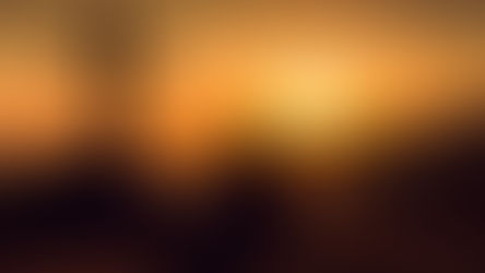 Silhouette of person sitting near a cross, gazing at a vibrant orange sunset over hills, creating a serene and contemplative mood.