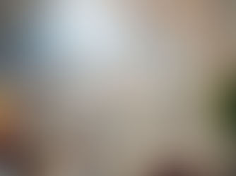 Priests in white robes sit in a cathedral with stained glass windows. Sunlight streams in, creating a serene atmosphere.
