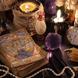 Tarot card "The Lovers" amid candles, clock, and crystals on a mystical table. Warm glow and vintage objects create an enchanting setting.