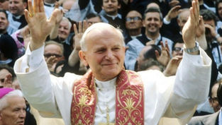 Cleric in white robe with ornate red stole raises hands, smiling. Crowd in background gestures with joy. Bright, joyful scene.