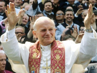 Cleric in white robe with ornate red stole raises hands, smiling. Crowd in background gestures with joy. Bright, joyful scene.