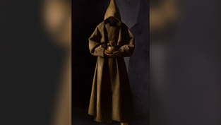Monk in a hooded brown robe holds a jar, standing barefoot in a dimly lit setting, creating a somber and mysterious mood.