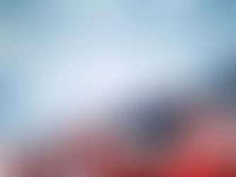 Folded American flag with stars and red-white stripes against a soft blue background with glowing star shapes