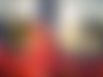 Close-up of a U.S. flag waving at sunset, with many American flags blurred in the background on a memorial-like field