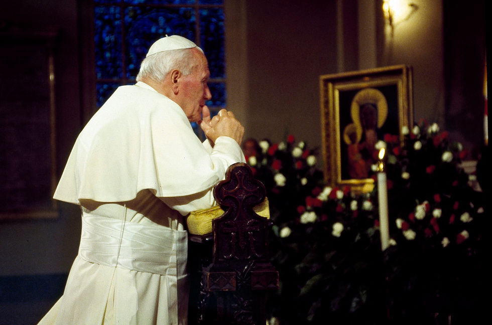Man in white robe praying at a church altar, hands clasped. Icon and flowers in background, warm lighting, contemplative mood.