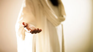 Outstretched hand in white robe, highlighting a small metallic object, warm glowing background, serene and inviting atmosphere.