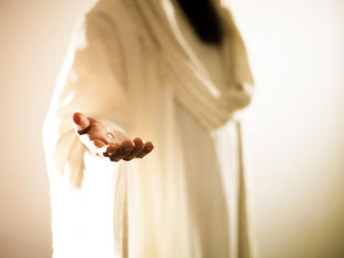 Outstretched hand in white robe, highlighting a small metallic object, warm glowing background, serene and inviting atmosphere.